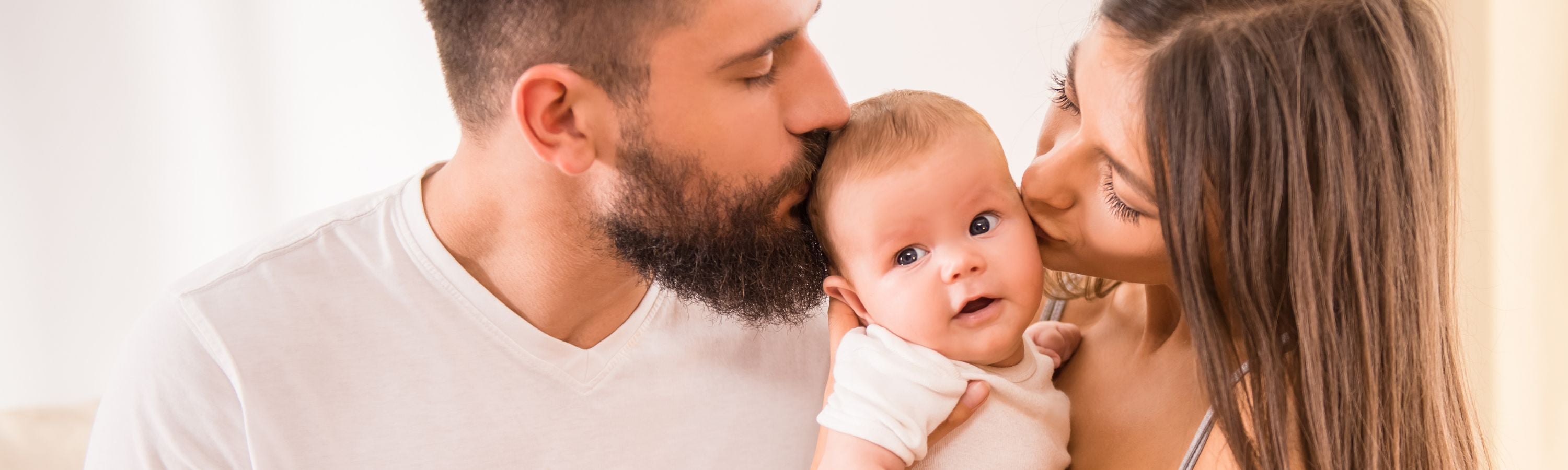 Parents kissing baby