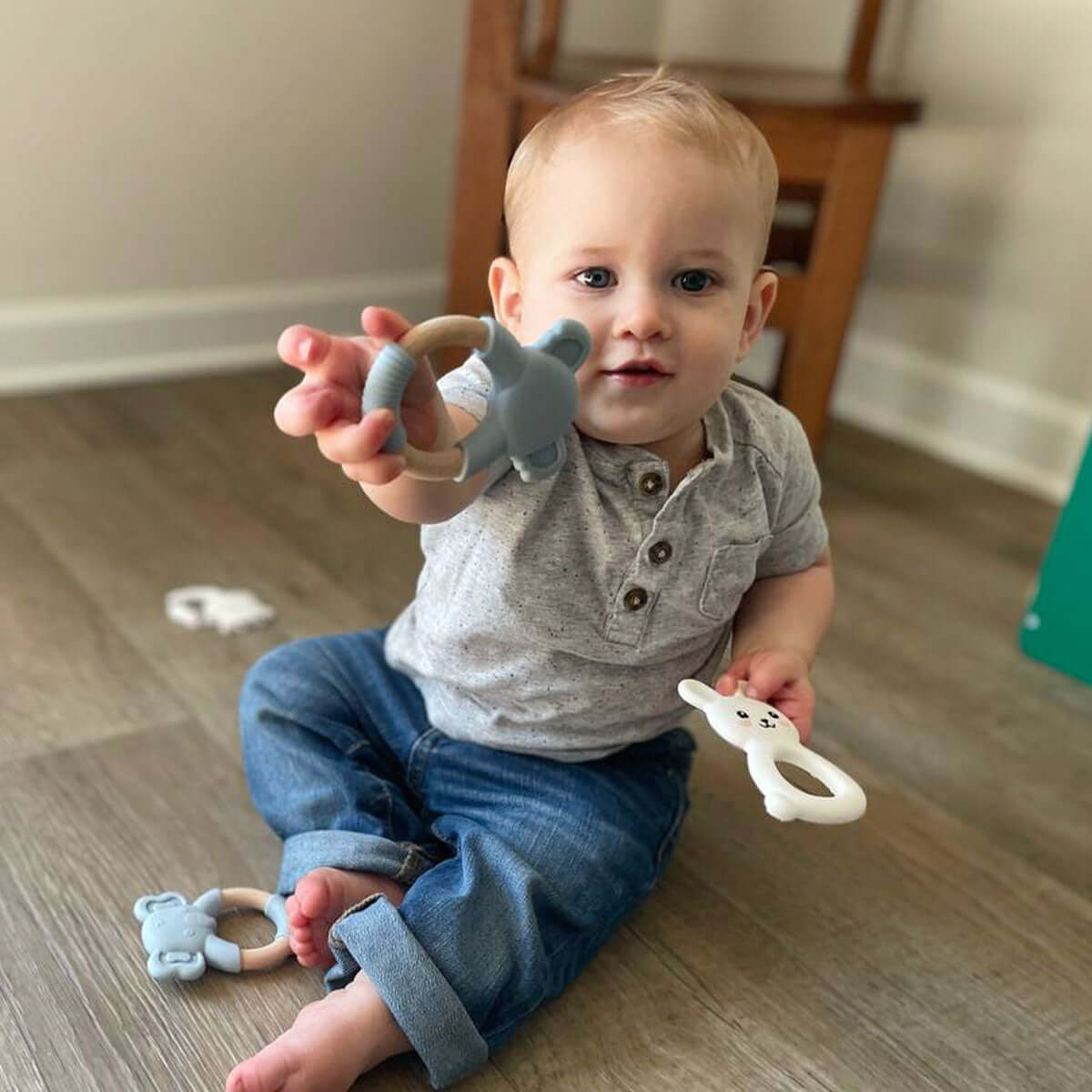 Baby passes MomMed Silicone Baby Teether cow toy to someone else