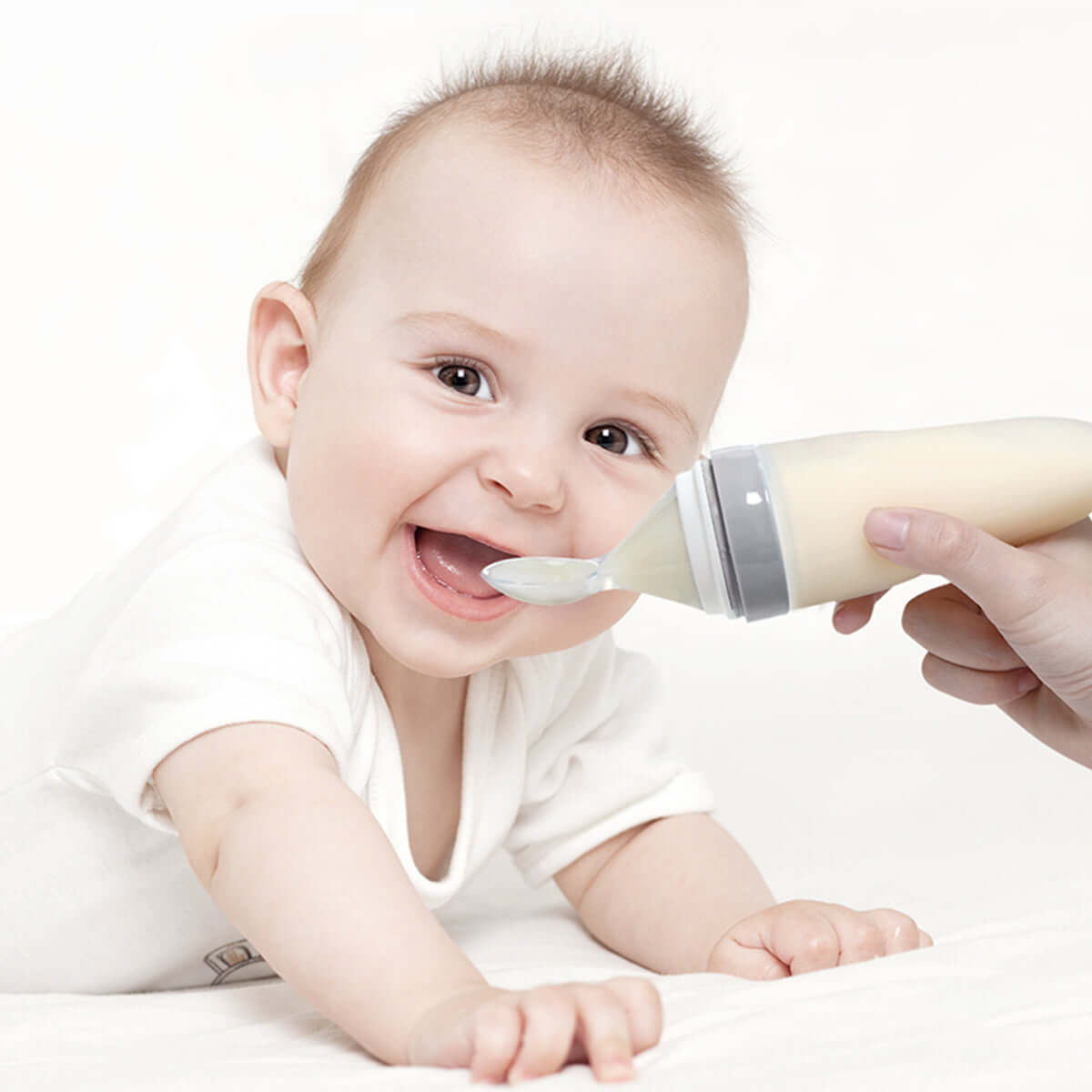 Mom is preparing to feed her baby using MomMed Baby Spoon Bottle Feeder