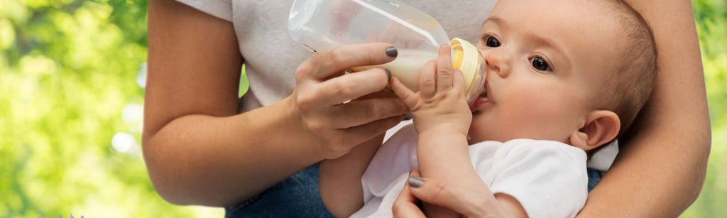 Baby drinking milk outdoors